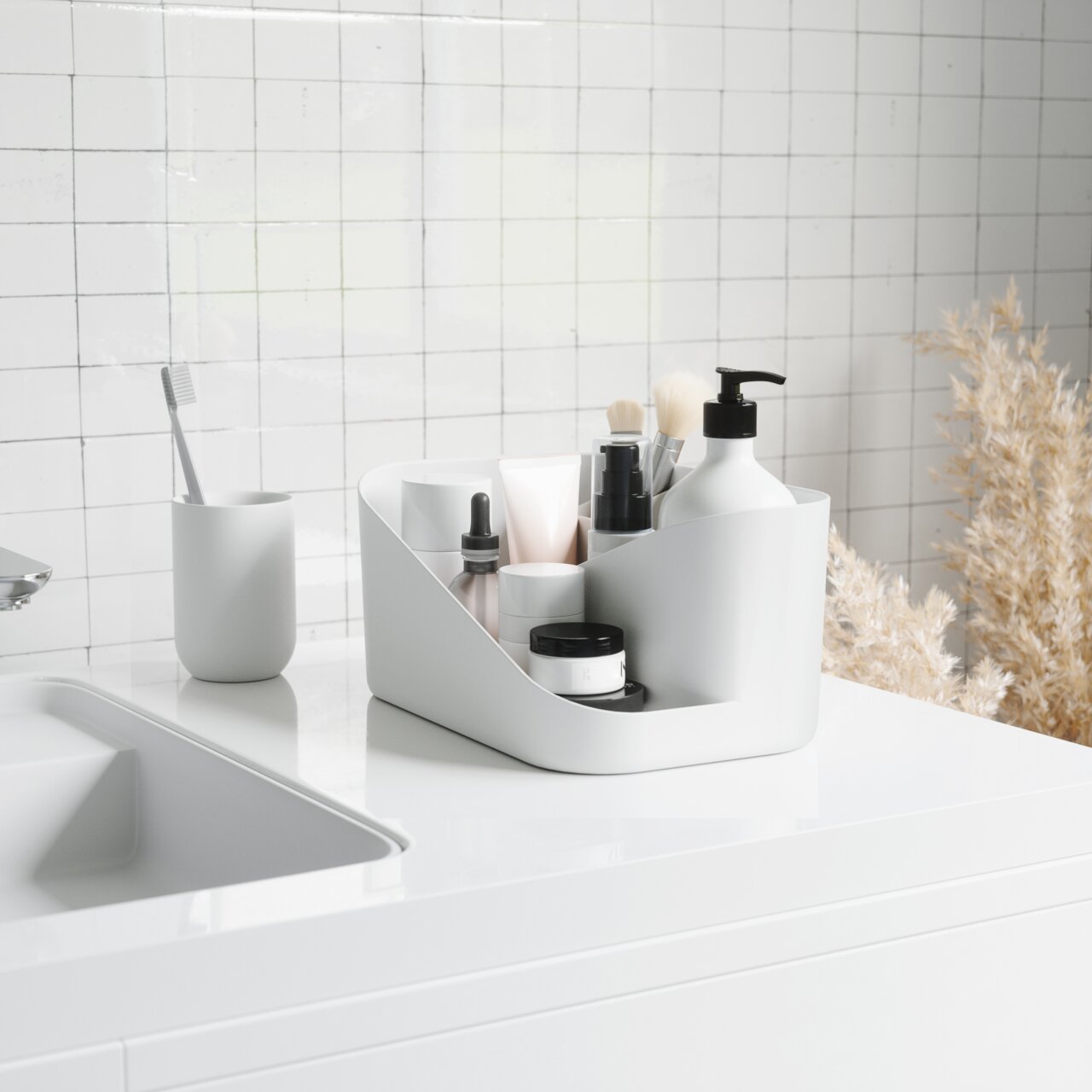 Weißer Glam Kosmetik-Organizer auf einem Badezimmerwaschtisch, gefüllt mit verschiedenen Kosmetikprodukten, seitliche Perspektive