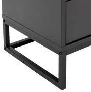 Detailansicht der unteren Ecke einer modernen, schwarzen Nachtkonsole mit Metallrahmen.