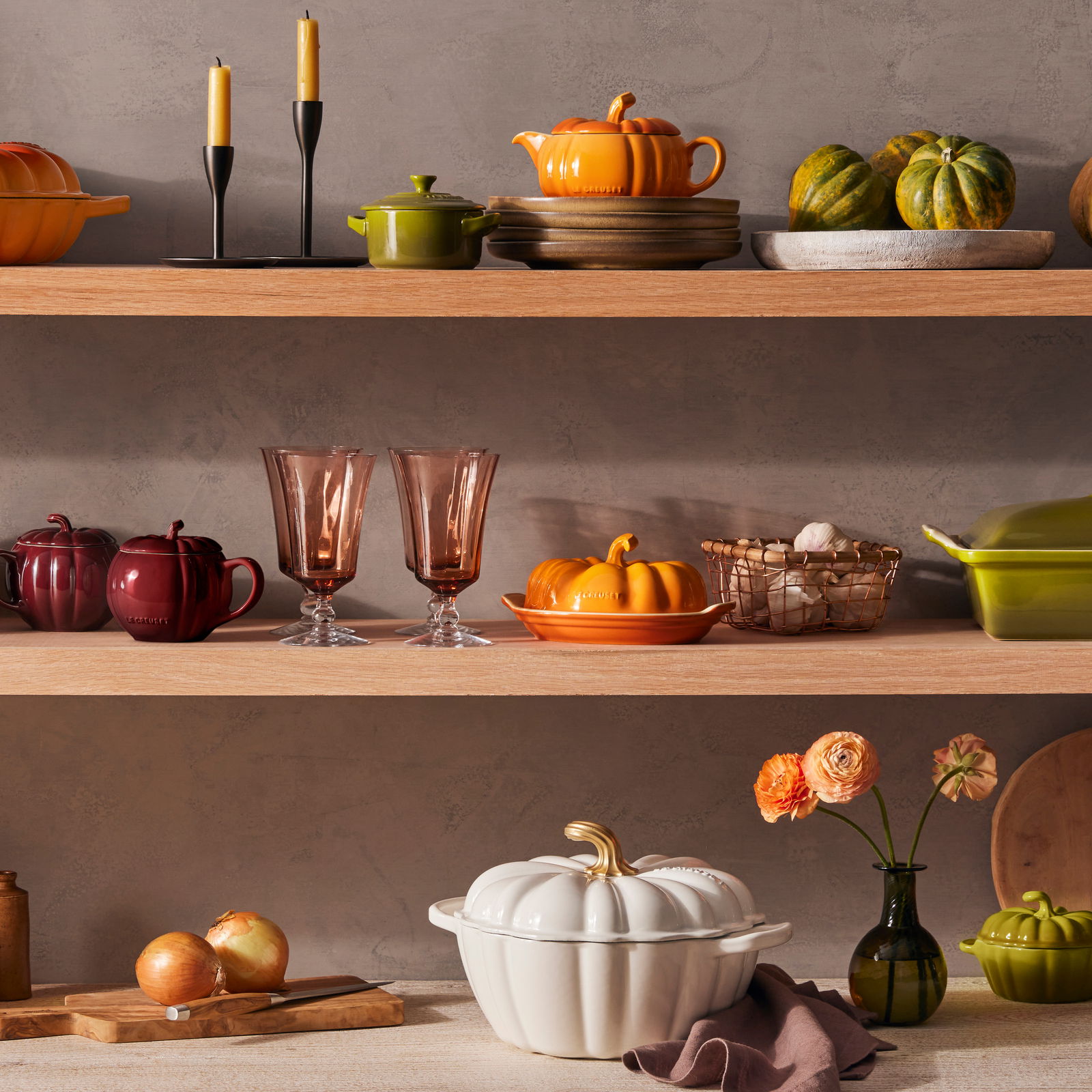 LE CREUSET Gourmet-Profitopf Kürbis 28cm Weiß HALLOWEEN Gourmet-Profitopf in Kürbisform, 28cm, in einem stilvollen Küchenregal aus Holz, umgeben von herbstlicher Dekoration. Perspektive: Frontalansicht.