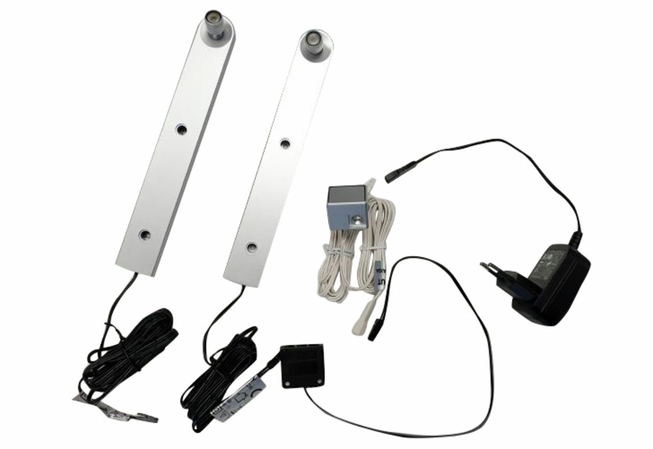 Twee zilveren ledstrips met kabels en voeding, gezien van bovenaf.