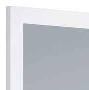 Nahaufnahme eines rechteckigen Spiegels mit weißem Rahmen, perspektivisch von der Seite aufgenommen.