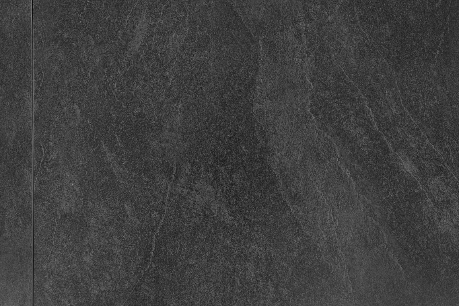 Draufsicht auf eine dunkle, strukturierte Tischoberfläche aus Steinoptik.