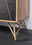 Nahaufnahme eines Sideboards mit geometrischen Metallbeinen und einer Kombination aus Holz- und Steinelementen, seitliche Perspektive.