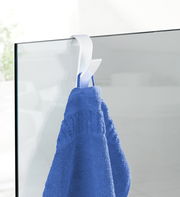 Weißer Haken für Handtuchheizkörper, der ein blaues Handtuch hält, seitliche Perspektive