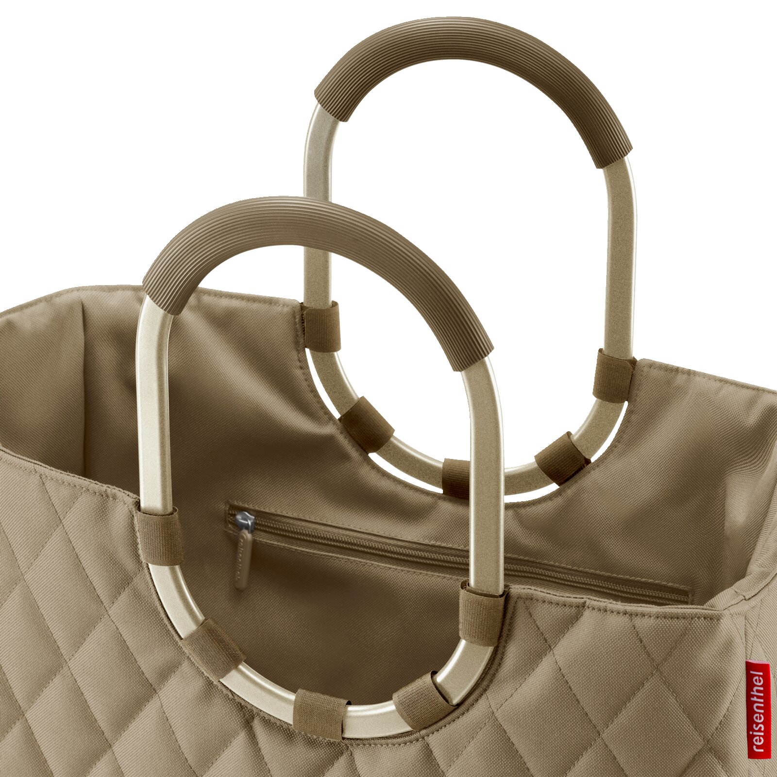 Close-up van een beige gewatteerde tas met ovale handvatten van metaal met een stoffen bekleding, gezien van bovenaf.