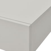 Nahaufnahme einer weißen Wandkonsole mit klaren Linien und glatter Oberfläche, perspektivisch von oben rechts fotografiert.