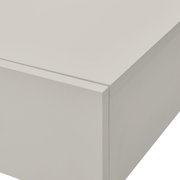 Close-up van een witte wandconsole met strakke lijnen en een glad oppervlak, gefotografeerd vanuit perspectief van rechtsboven.