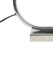 Nahaufnahme eines modernen, gebogenen Lampenfußes aus Metall mit Kabel, seitliche Perspektive.