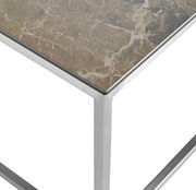 Nahaufnahme eines Beistelltisches mit einer Tischplatte in Marmoroptik und einem silbernen Metallrahmen, von oben betrachtet.