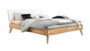 Modernes Bett mit gepolstertem Kopfteil, Holzrahmen und stilvollen Kissen, seitliche Perspektive