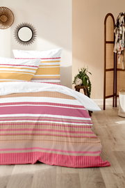 Bettwäsche-Set mit Streifenmuster in Rosa, Gelb und Weiß, auf einem Bett in einem gemütlichen Schlafzimmer, seitliche Perspektive.