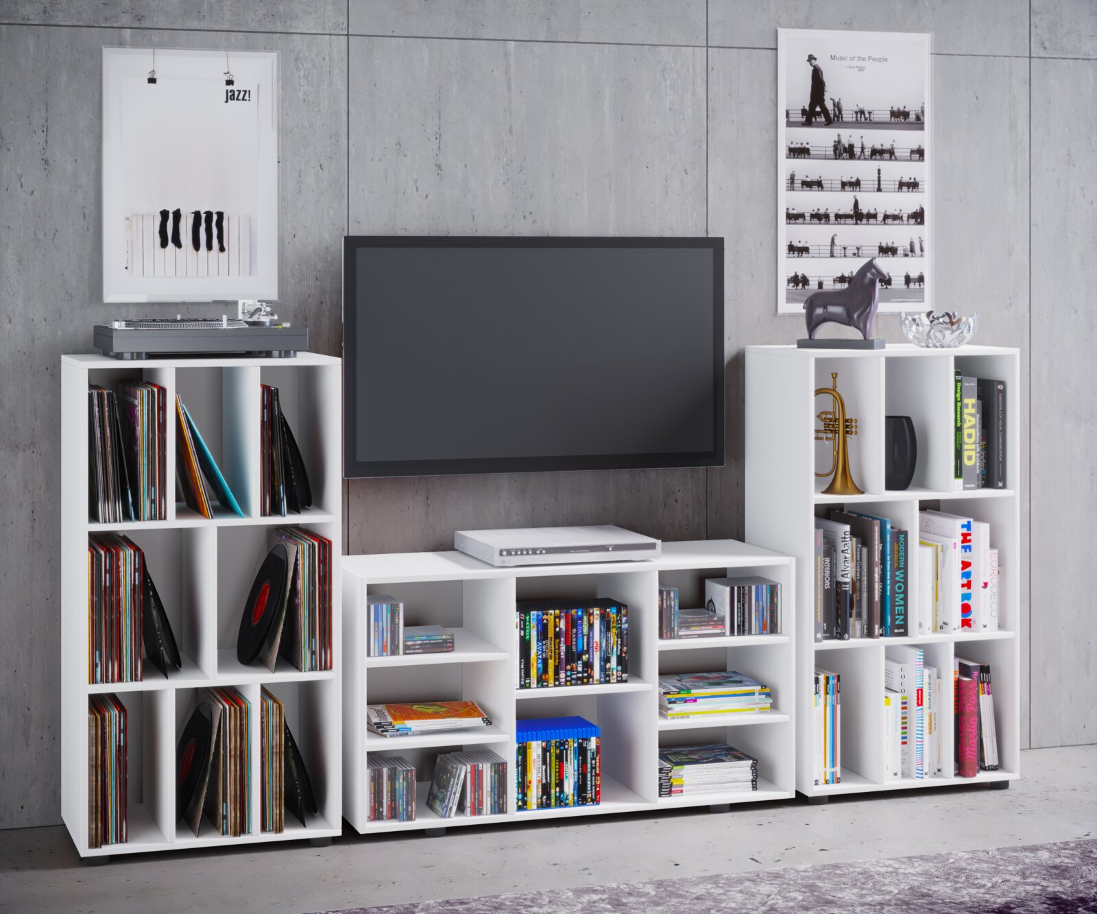 Frontale Wohnzimmerszene mit weißen Medien- und Regalmodulen auf Rollen, gefüllt mit Schallplatten, Büchern und DVDs, mit wandmontiertem Flachbild-TV in der Mitte und Plattenspieler links vor grauer Betonwand.