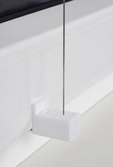 Nahaufnahme eines weißen Plissee-Halters mit gefädeltem Draht, montiert an einem Fensterrahmen.