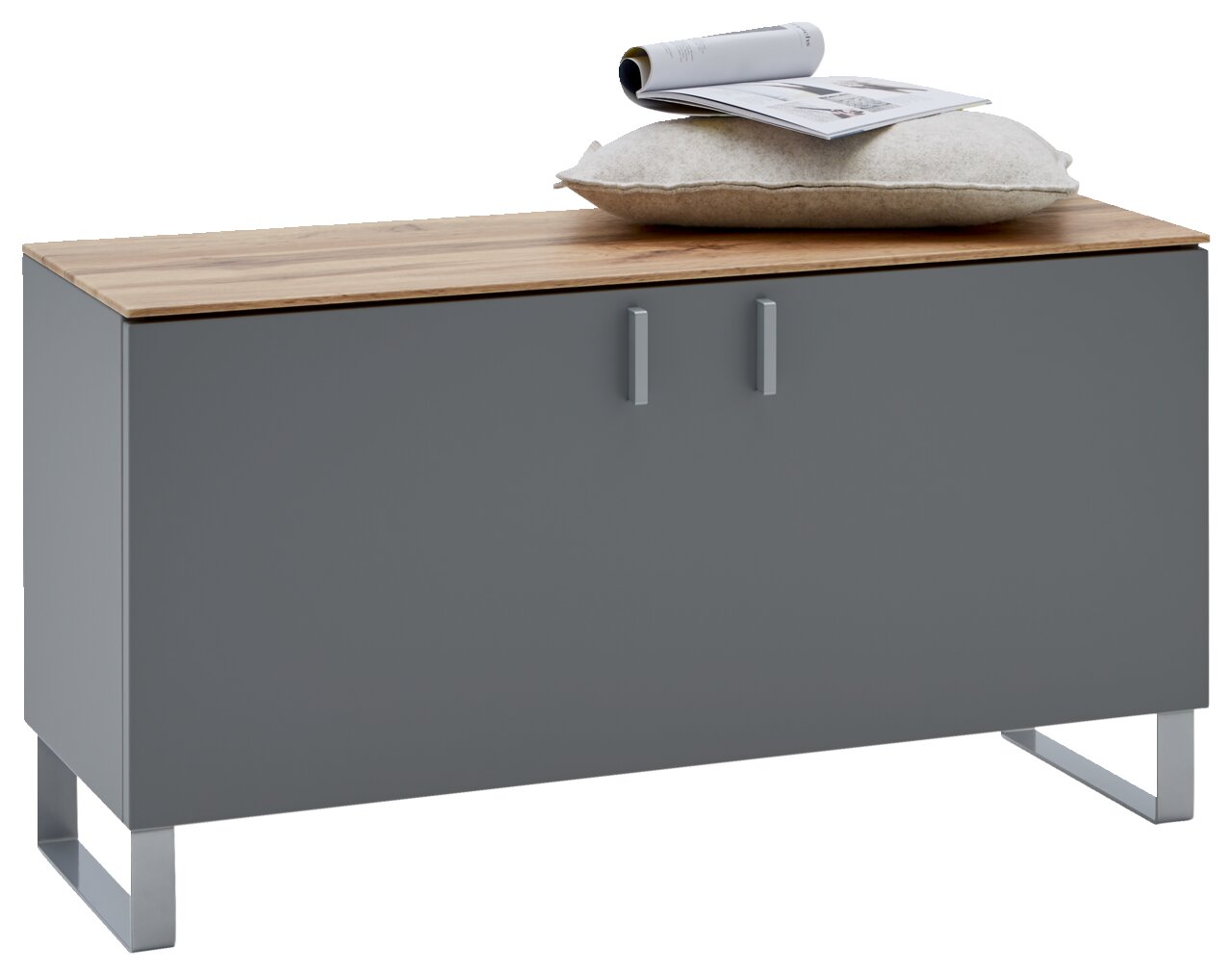 Garderobenbank in modernem Design mit grauer Front und Holzoberfläche, darauf ein Kissen und eine Zeitschrift, Perspektive von vorne.