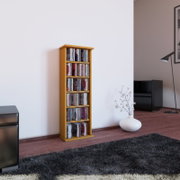 Schmales, hohes CD-Regal aus hellem Holz mit mehreren Fächern, gefüllt mit CDs, freistehend an einer weißen Wand im Wohnzimmer; Perspektive: frontale Ansicht leicht von links auf Augenhöhe.