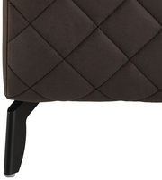 Nahaufnahme eines Boxspringbettes mit gestepptem Stoffbezug und schwarzem Bein, seitliche Perspektive