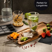 Eiswürfelform in Nahaufnahme auf einem Tisch mit Longdrink-Glas, Früchten und Gewürzen, perfekt für Longdrinks.