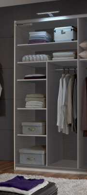 Ein geöffneter Kleiderschrank mit mehreren Regalböden, auf denen gefaltete Kleidung und Boxen liegen, sowie einer Kleiderstange mit hängenden Hemden. Die Perspektive zeigt den Schrank von vorne.