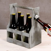 Antiker Flaschenträger aus Holz mit sechs Bierflaschen, seitliche Perspektive, integrierter Flaschenöffner in Benutzung.