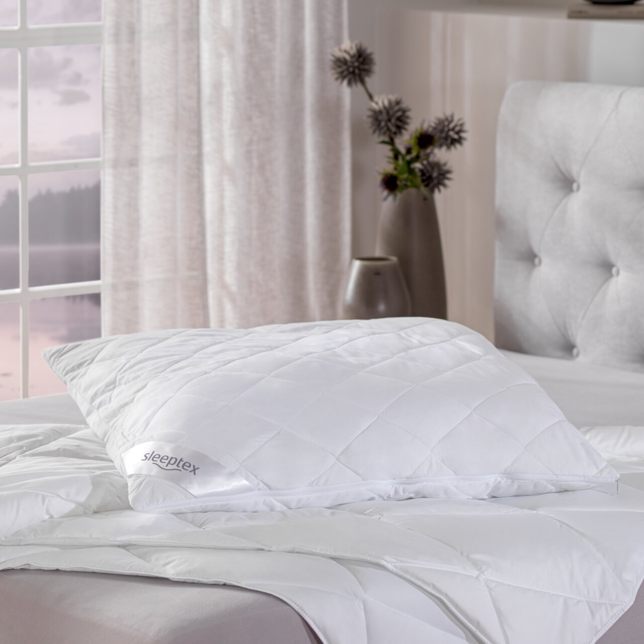 Weißes Sommerbett-Set von Sleeptex mit Kissen und Decke auf einem Bett, seitliche Perspektive.