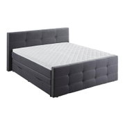 Graues Boxspringbett mit gestepptem Kopf- und Fußteil, seitliche Perspektive