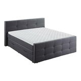 Graues Boxspringbett mit gestepptem Kopf- und Fußteil, seitliche Perspektive