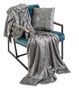 Graue Wohndecke und Kissen mit winterlichem Muster auf einem Sessel, seitliche Perspektive