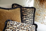 Drei Dekokissen mit Tiermuster in Nahaufnahme auf einem Sofa, Perspektive von vorne.