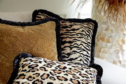 Drei Dekokissen mit Tiermuster in Nahaufnahme auf einem Sofa, Perspektive von vorne.