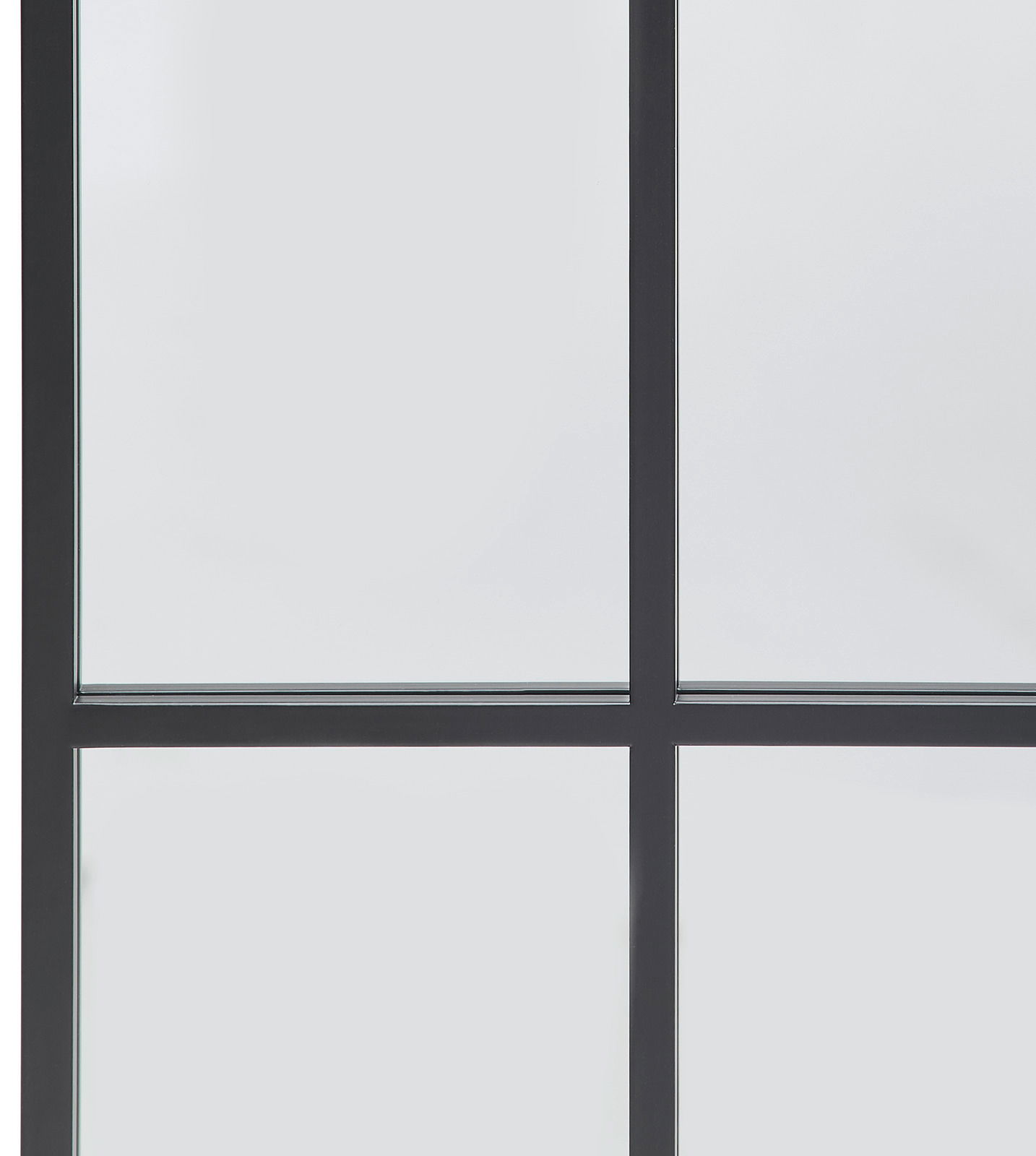 Nahaufnahme eines großen Spiegels mit schwarzem Rahmen und Gitterdesign, perspektivisch von vorne aufgenommen.