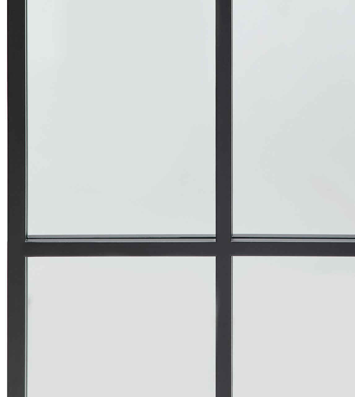 Nahaufnahme eines großen Spiegels mit schwarzem Rahmen und Gitterdesign, perspektivisch von vorne aufgenommen.