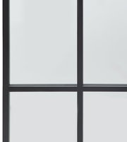 Nahaufnahme eines großen Spiegels mit schwarzem Rahmen und Gitterdesign, perspektivisch von vorne aufgenommen.