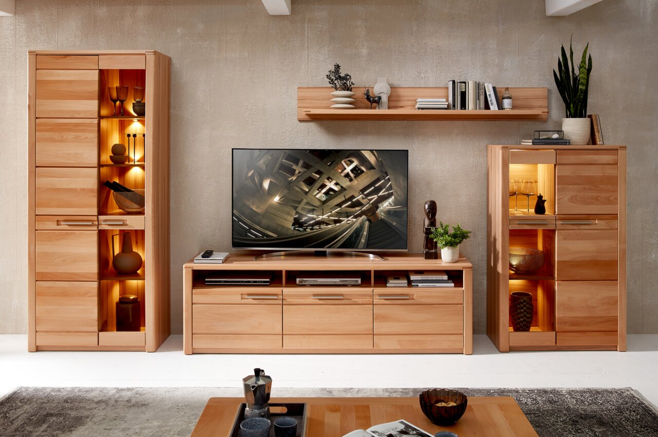 TV-Lowboard aus Holz in einem modernen Wohnzimmer, frontal betrachtet, mit Dekorationen und einem Fernseher darauf.