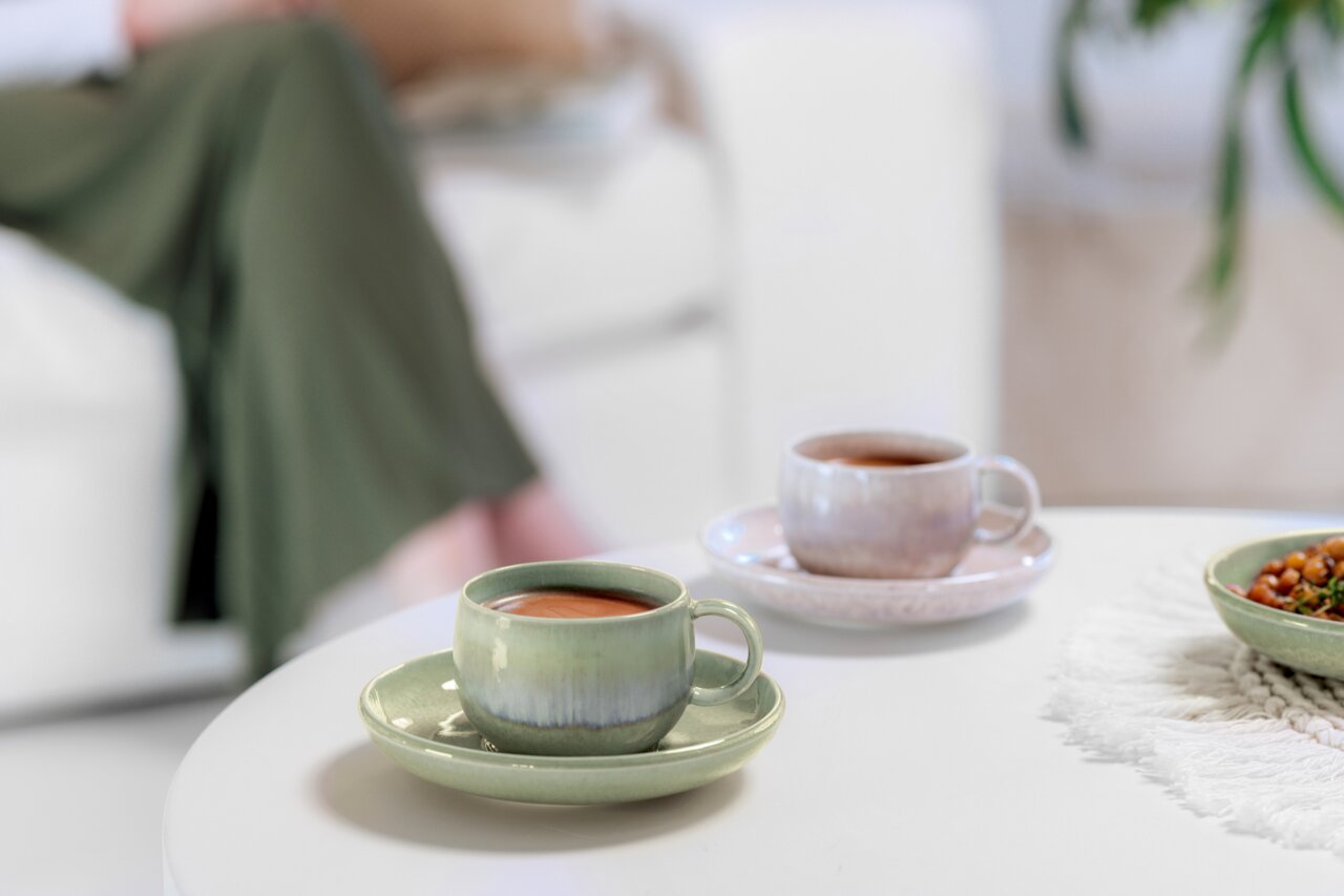 Like by Villeroy & Boch Espressotasse PERLEMOR ALGA Espressotasse in sanftem Grün auf einem Tisch, aus der Vorderperspektive fotografiert, mit einer weiteren Tasse im Hintergrund.