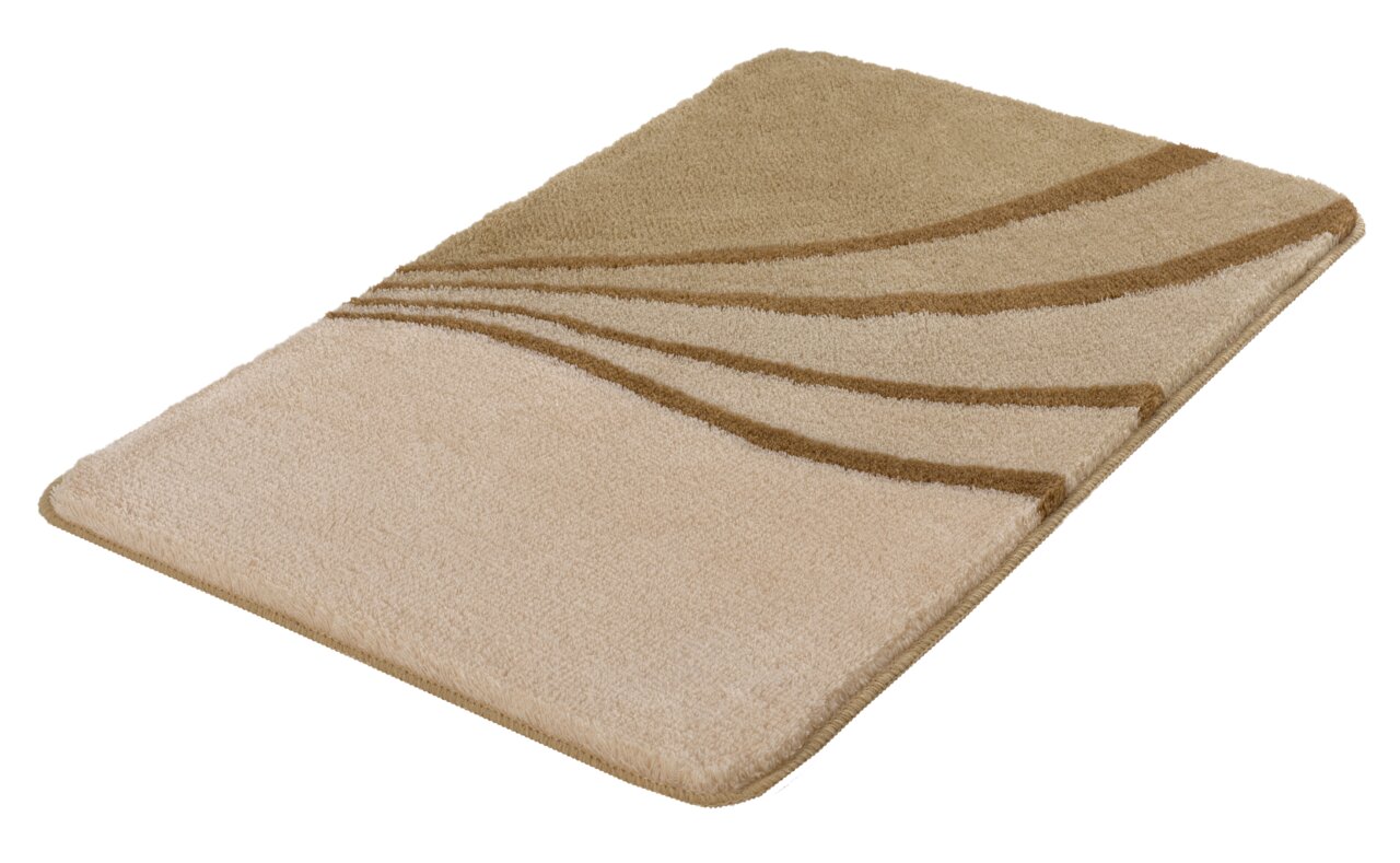 Beiger Badteppich mit wellenförmigem Muster in verschiedenen Brauntönen, perspektivisch von der Seite fotografiert.