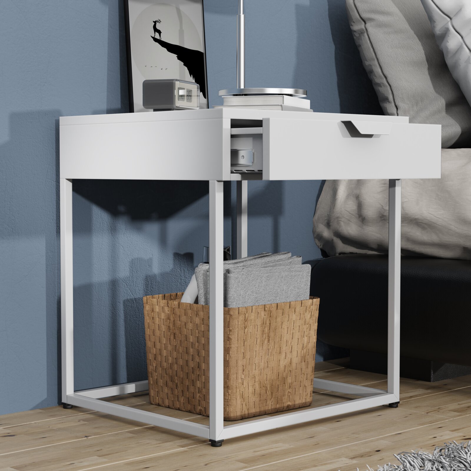 Weißer Nachttisch/Beistelltisch im modernen Design mit Metallgestell und halb geöffneter Schublade, seitliche Frontansicht aus leicht niedriger Perspektive neben einem Bett.