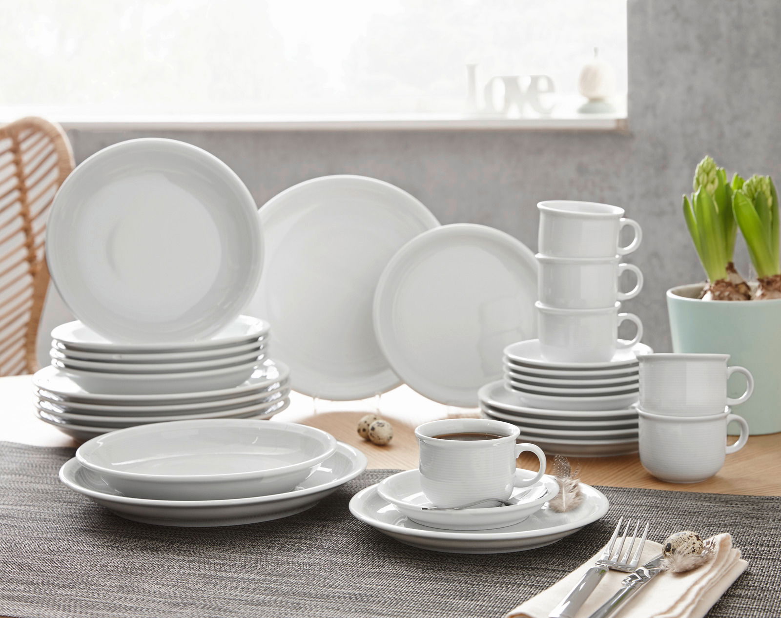 Kombiservice Trend weiß 30-tlg, bestehend aus Tellern, Tassen und Untertassen, auf einem Tisch arrangiert, seitliche Perspektive