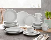 Kombiservice Trend weiß 30-tlg, bestehend aus Tellern, Tassen und Untertassen, auf einem Tisch arrangiert, seitliche Perspektive