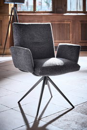 Moderner Armlehnstuhl mit grauem Stoffbezug und schwarzem Metallgestell, seitliche Perspektive.