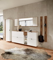 Moderne Garderobeneinrichtung in Weiß mit hängendem Schuhschrank, Spiegel und Garderobenpaneel, seitliche Perspektive.