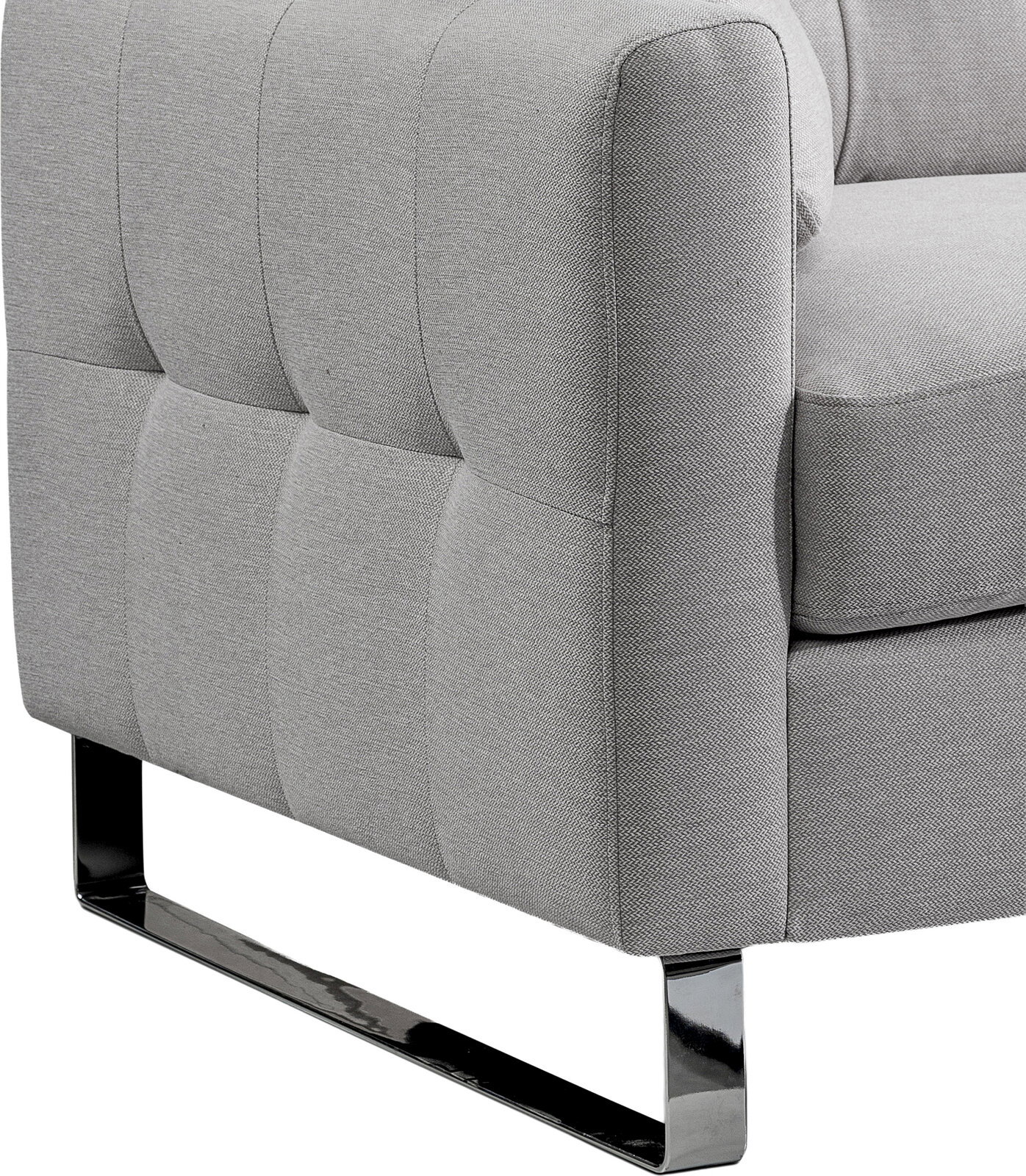 Detailaufnahme eines hellgrauen, gepolsterten Stoffsofas mit gesteppter Seitenpartie und glänzendem Metallkufenfuß, seitliche Perspektive