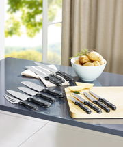 Verschiedene Küchenmesser, darunter ein Brötchenmesser, auf einem Tisch in einer modernen Küche, mit Blick auf ein Fenster im Hintergrund.