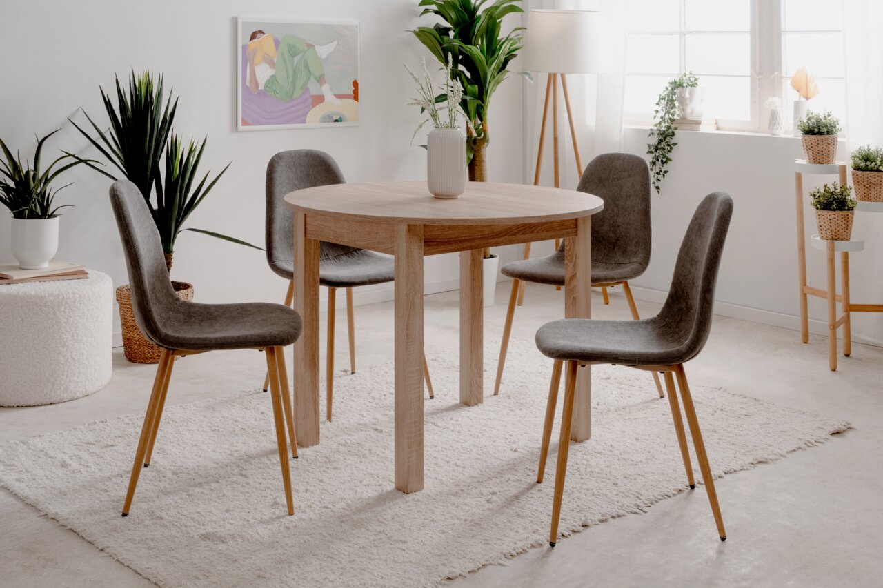 Z2 Funktions-Esstisch rund COBURG Runder Esstisch aus Holz mit vier grauen Stühlen in einem hellen, modernen Raum, seitliche Perspektive