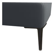 Nahaufnahme eines Boxspringbettbeins aus dunklem Holz mit grauem Stoffbezug, seitliche Perspektive