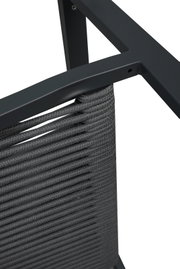 Detailfoto van een tuinstoel met grijs vlechtwerk en een metalen frame, gezien van bovenaf.