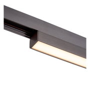 Close-up schuin zijaanzicht van een zwarte lineaire LED-railarmatuur met geïntegreerde lichtbalk en warme diffuser op witte achtergrond