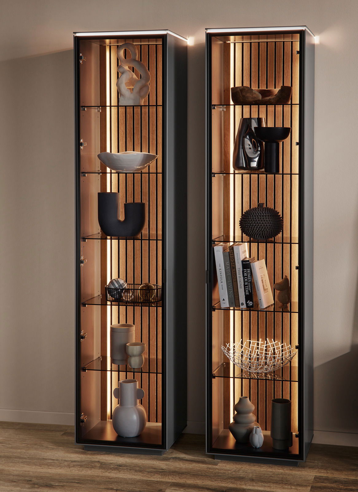 Zwei moderne Vitrinen mit Glasregalen und dekorativen Objekten, frontal betrachtet, mit integrierter Beleuchtung.