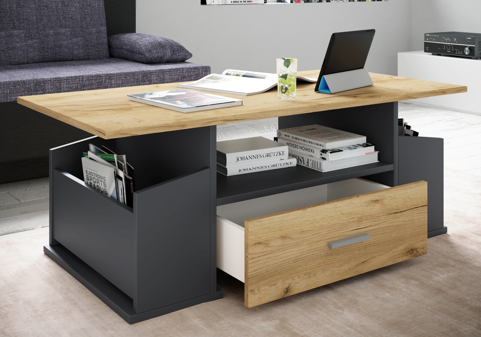 Moderner Couchtisch in Eiche-Optik mit anthrazitfarbenem Korpus, Ablagefächern und geöffneter Schublade im Wohnzimmer – Perspektive: frontale, leicht seitliche Ansicht