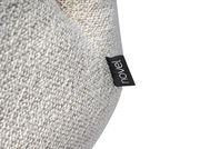 Nahaufnahme eines Sessels mit grob gewebtem, cremefarbenem Stoff und einem schwarzen Etikett mit der Aufschrift 'novel'.