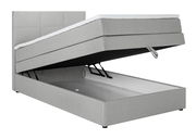 Graues Boxspringbett mit geöffnetem Bettkasten, seitliche Perspektive